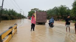 Respons Cepat Laporan Call Center 110, Polsek Padang Tualang Atur Lalu Lintas di Jalan Sumur Bor yang Tergenang Air